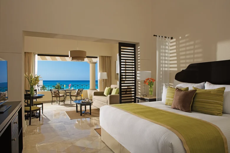 Junior Suite Ocean View with king bed and private furnished balcony overlooking the Sea of Cortez at Dreams Los Cabos Suites Golf Resort & Spa.