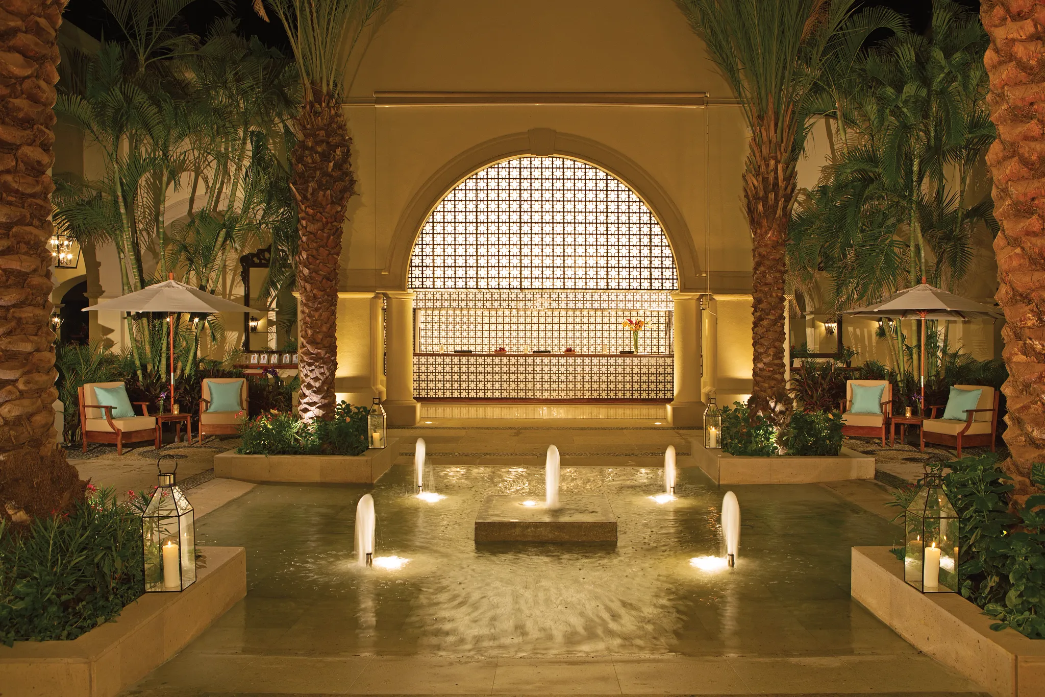 Elegant resort lobby with illuminated fountain and reception desk at Dreams Los Cabos Suites Golf Resort & Spa.