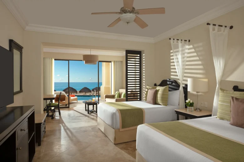 Preferred Club Junior Suite Oceanfront Swim Out with two double beds and terrace access to oceanfront pool at Dreams Los Cabos Suites Golf Resort & Spa.