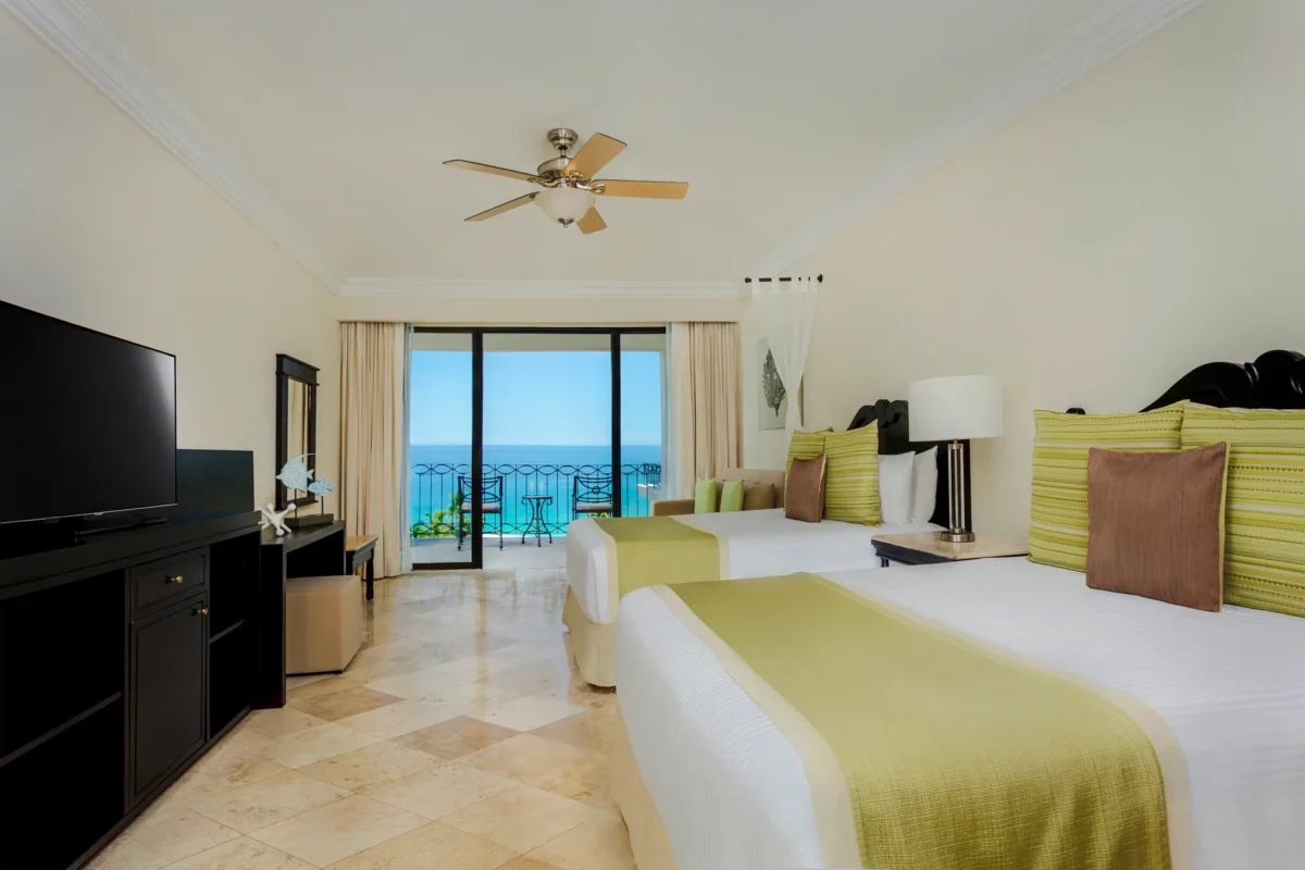 Preferred Club One Bedroom Suite Ocean View bedroom with two double beds and balcony overlooking the ocean at Dreams Los Cabos.