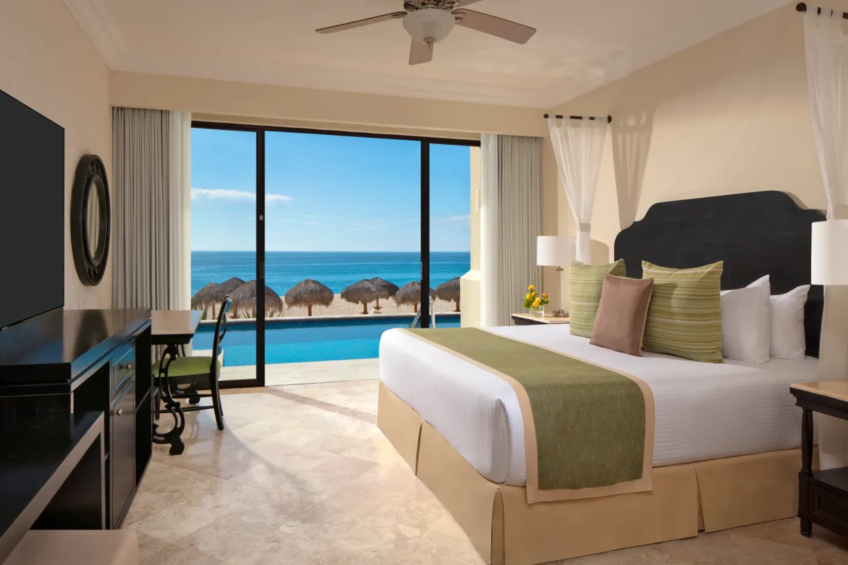 Preferred Club One Bedroom Suite Oceanfront Swim Out bedroom with king bed and oceanfront pool view at Dreams Los Cabos.